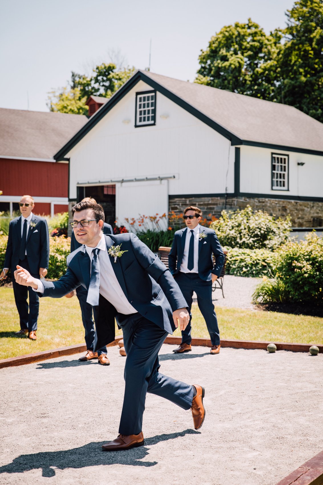  Groomsmen play bocce ball before a barn wedding in Central NY 