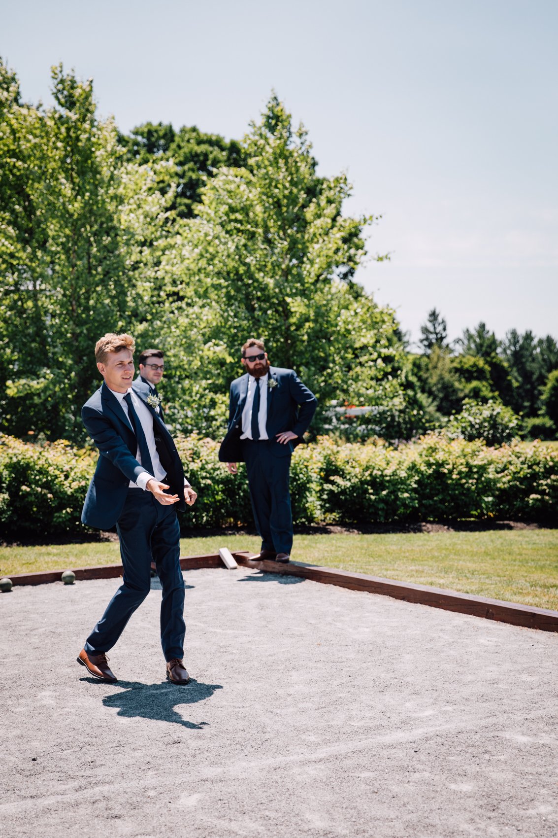  Groomsmen play bocce ball before a barn wedding in Central NY 
