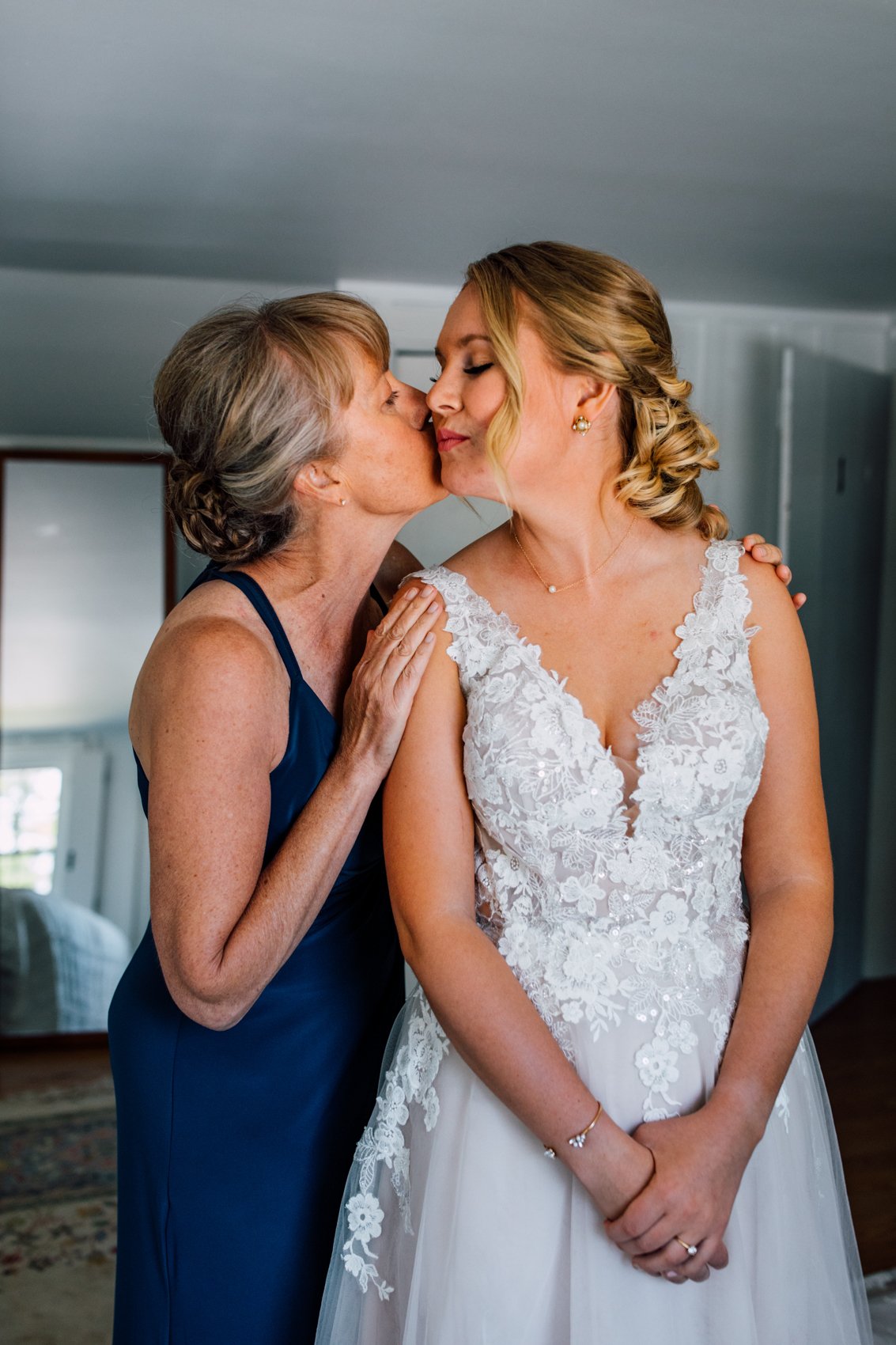  Bride’s mom kisses her on the cheek while taking getting ready photos at Windridge Estate Red Barn in Cazenovia NY 