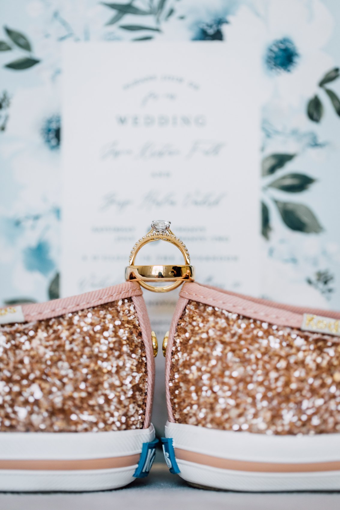  Gold wedding ring balance on top of sparkly wedding shoes 