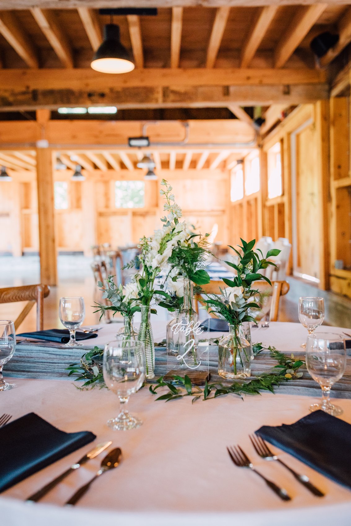  Simple wedding centerpieces with wildflowers and greenery in mismatched clear glass vases 