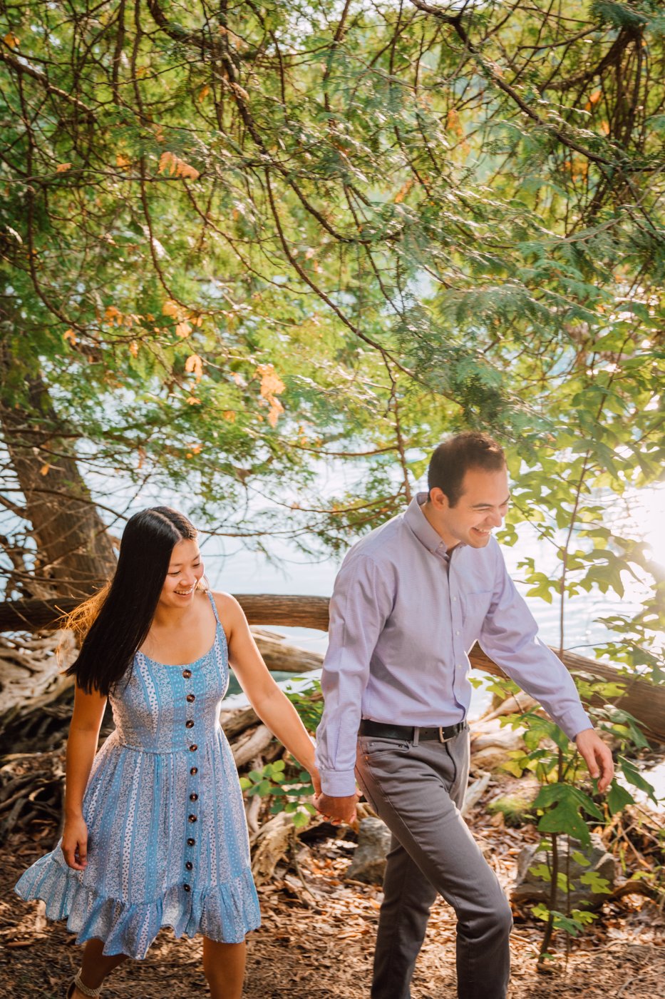  Engaged couple holding hands while walking through the trees during forest engagement photos 