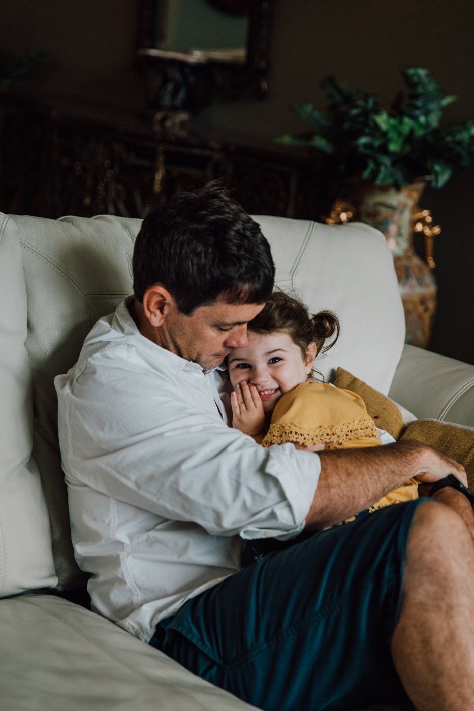  Father and daughter cuddle during family photography session by Brittany Juravich 