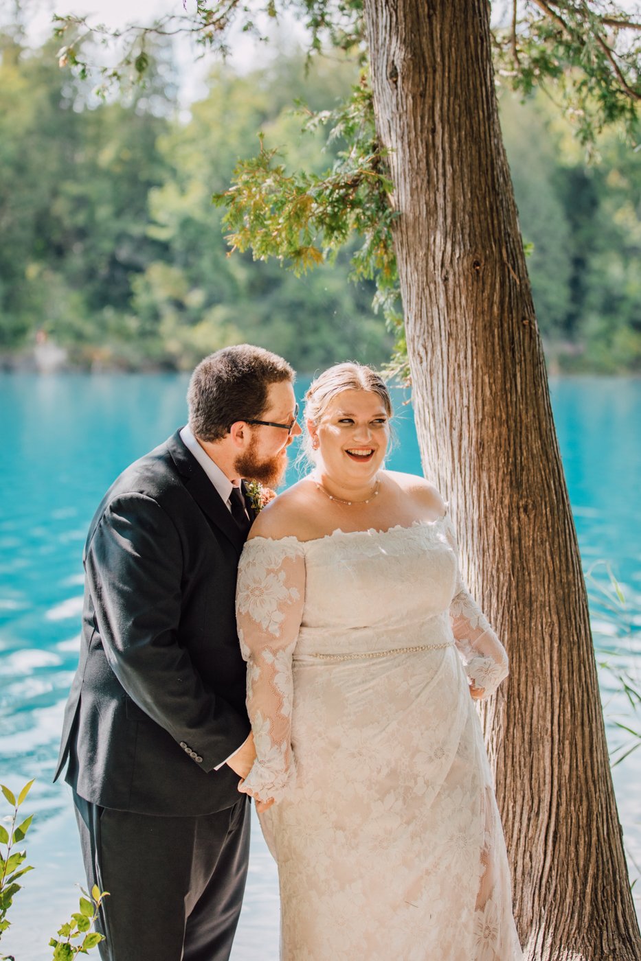  Bride and Groom pose for wedding photos during their lakeside wedding at Green Lakes State Park 
