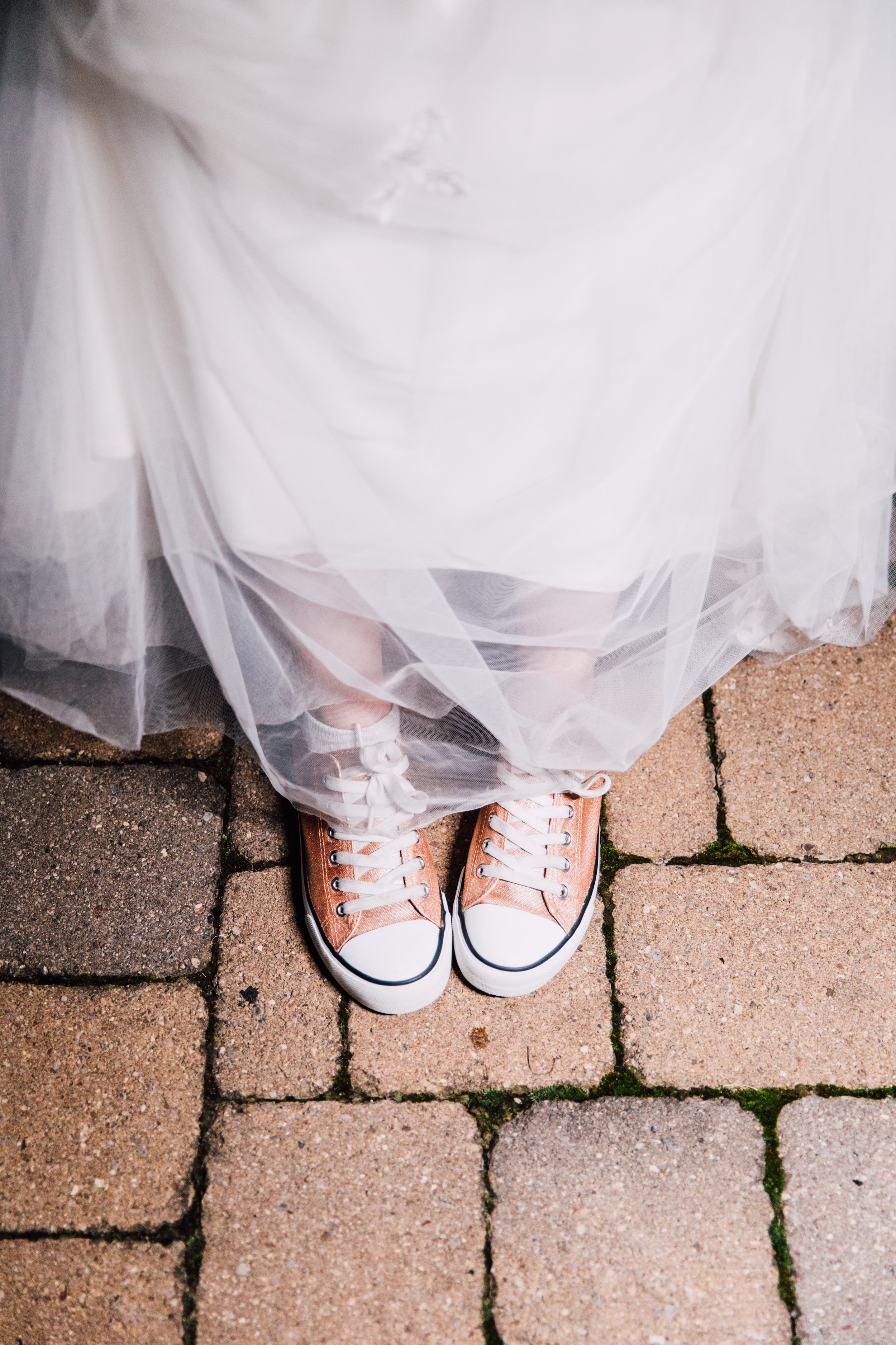  Bride shows off her Chuck Taylor shoes at her wedding reception 