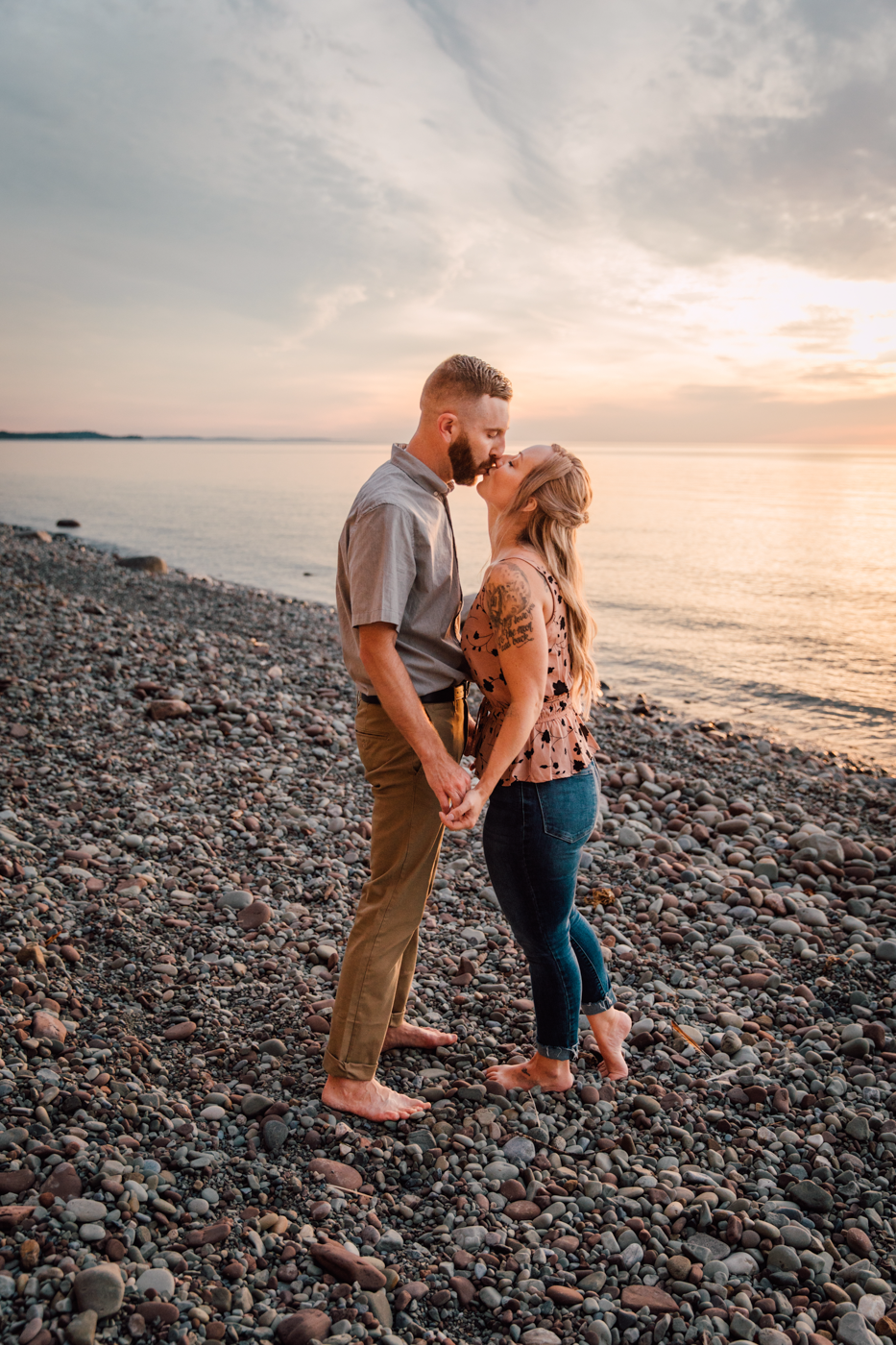  Engaged couple kisses at sunset during Oswego NY lakefront engagement photos 