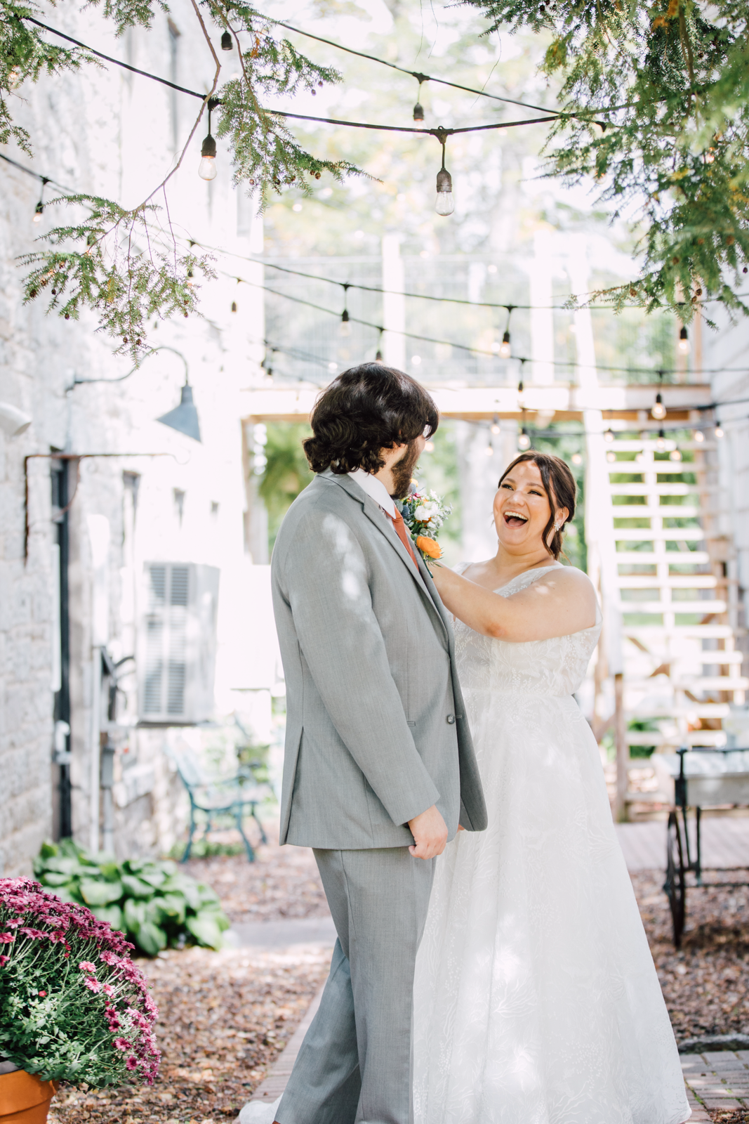  Bride smiles widely during wedding first look in the courtyard at Sinclair of Skaneateles 