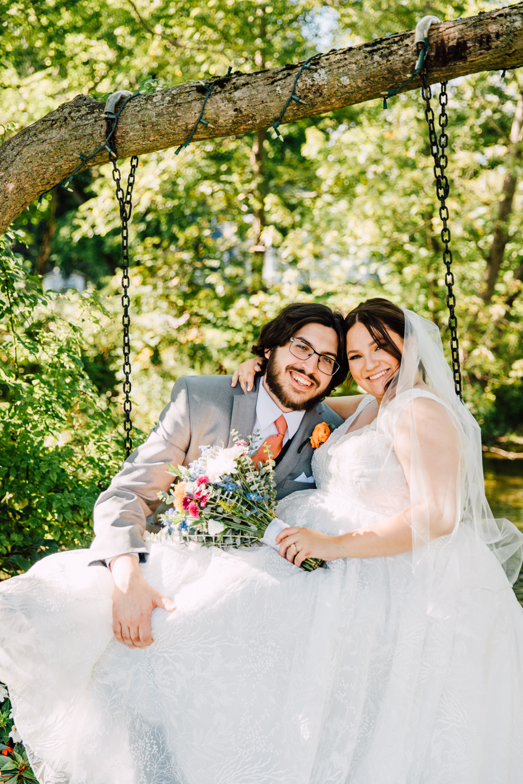  Bride and Groom cuddle on an outdoor swing at their Sinclair of Skaneateles industrial wedding 