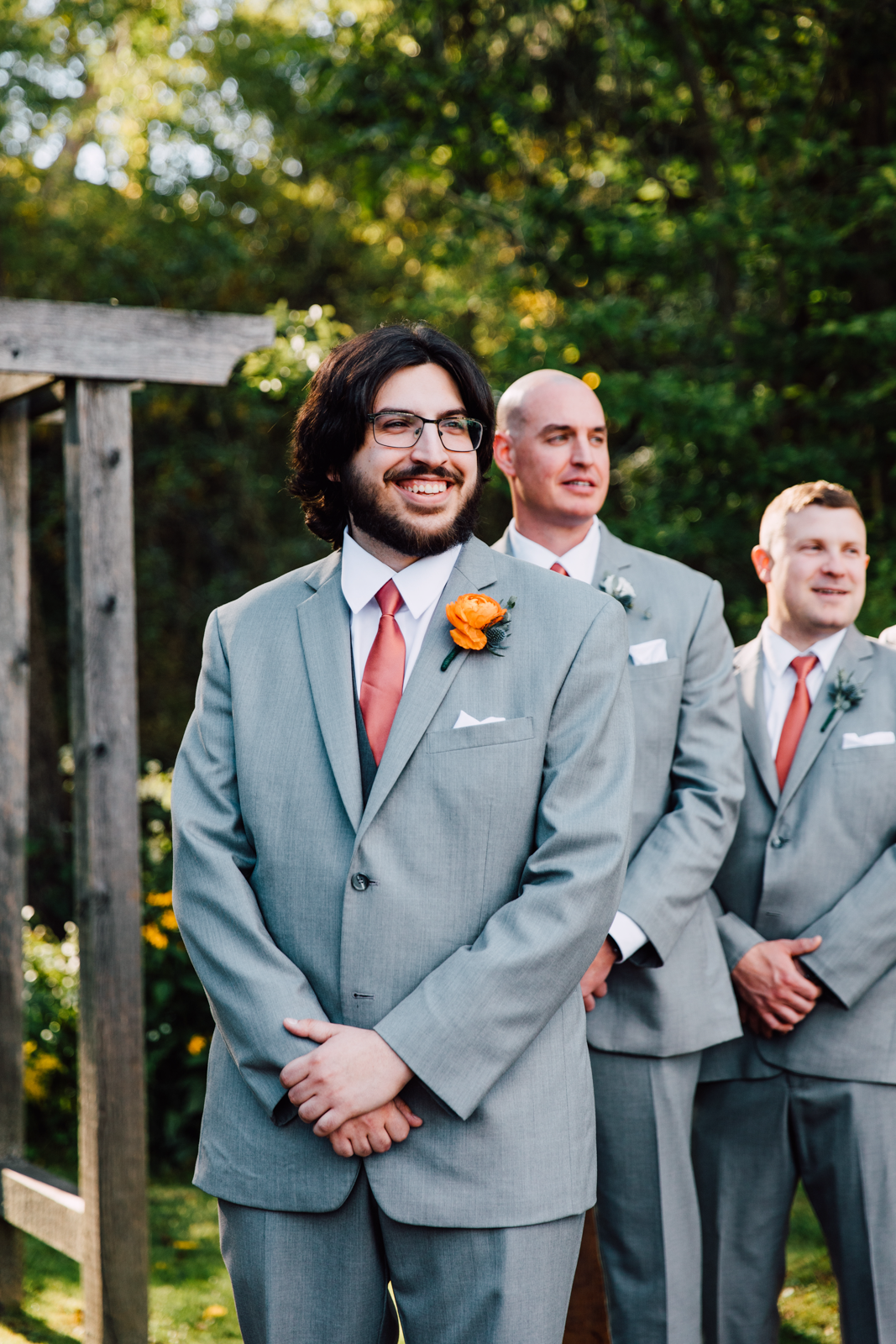  Groom smiles as he watches his Bride walk down the aisle at rustic outdoor ceremony at Sinclair of Skaneateles 