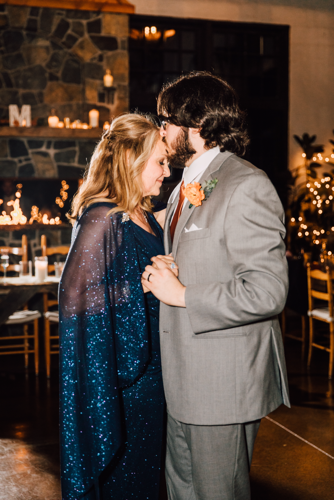  Groom kisses his mom on the forehead during mother son dance at his Sinclair of Skaneateles wedding reception 