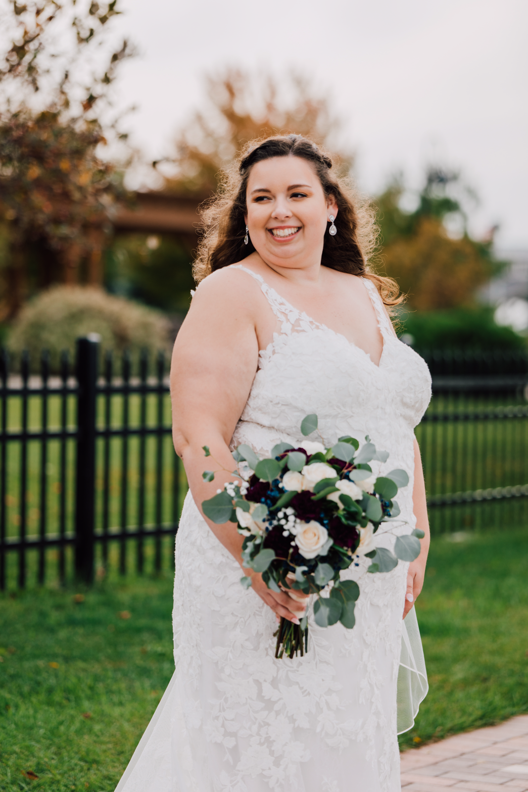  Portrait of a Bride smiling over her shoulder with a bouquet of white flowers and eucalyptus 