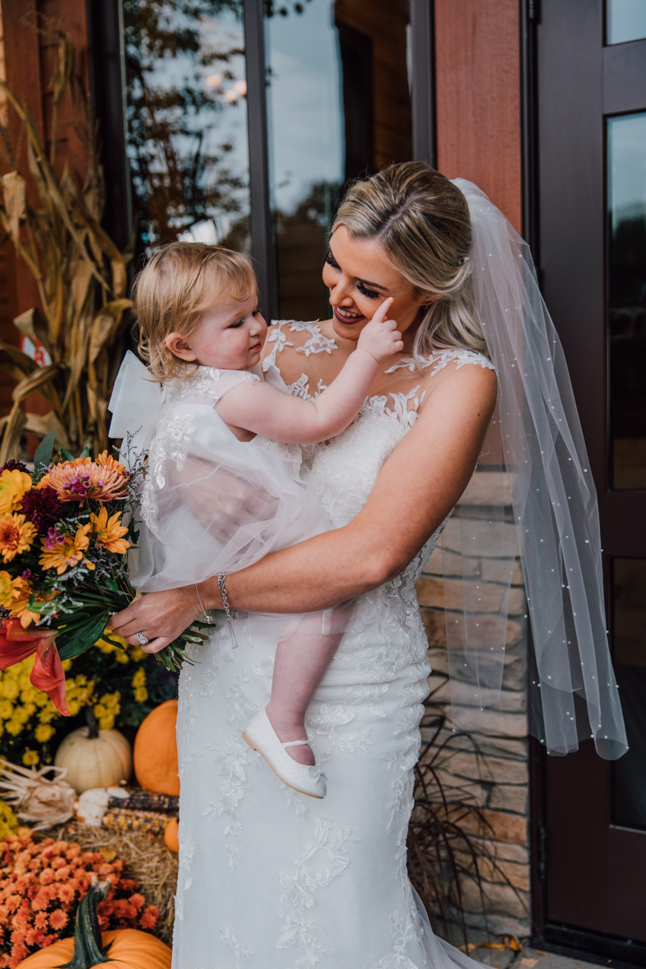  Bride holds her daughter during fall wedding photos in Altmar NY 