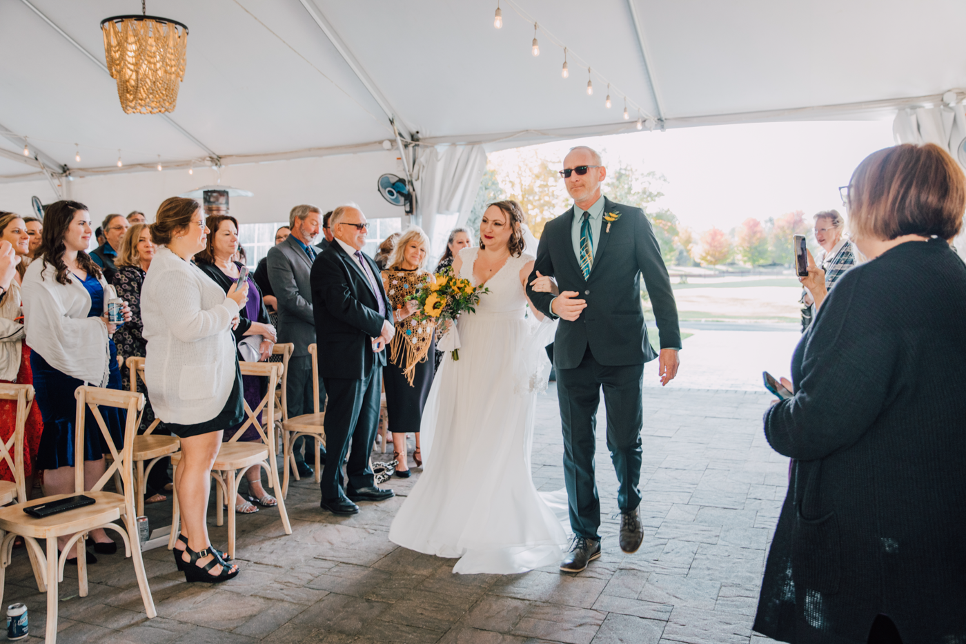  Bride walks down the aisle of her tented wedding ceremony at Tailwater Lodge 