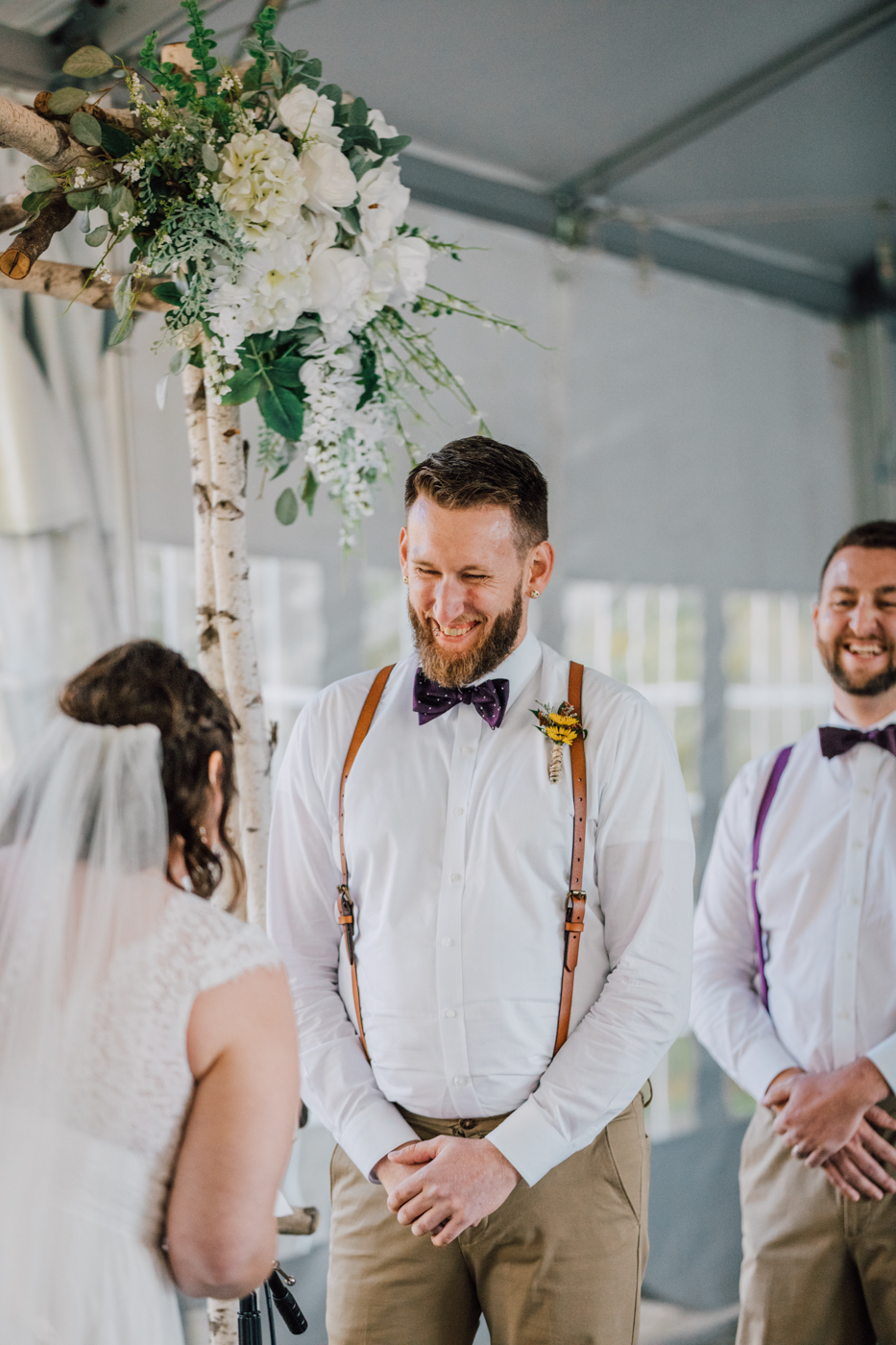  Groom smiles at his Bride during tented wedding ceremony at Tailwater Lodge 
