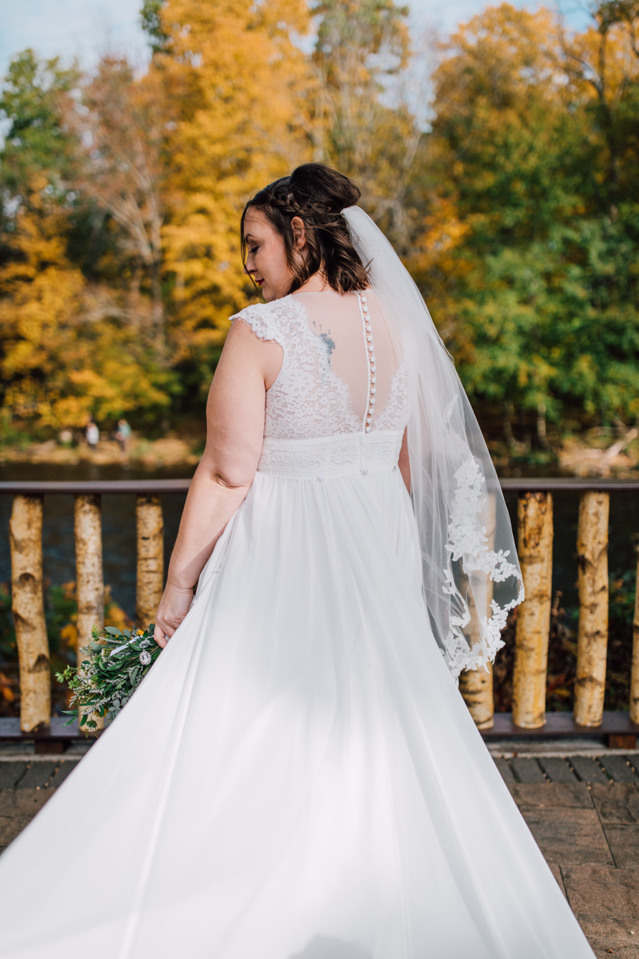  Bride shows off the back of her dress during fall wedding photos in Central NY 