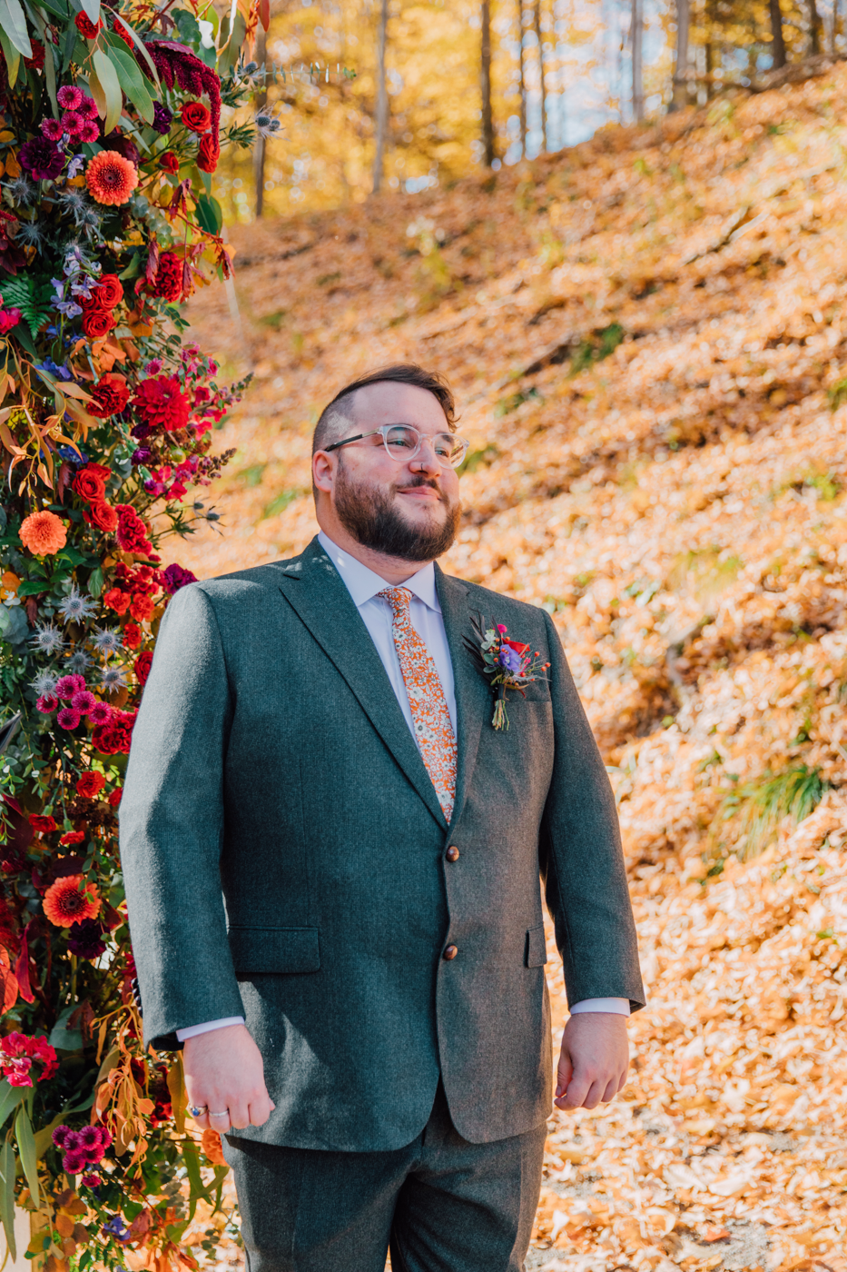  Groom smiles as he watches his Bride walk down the aisle at their outdoor fall wedding in Ithaca NY 