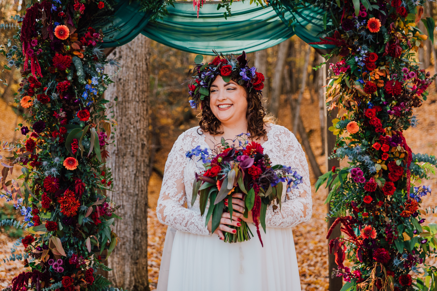  Bride with floral crown poses with her moody wedding flowers during her forest wedding at New Park Ithaca 