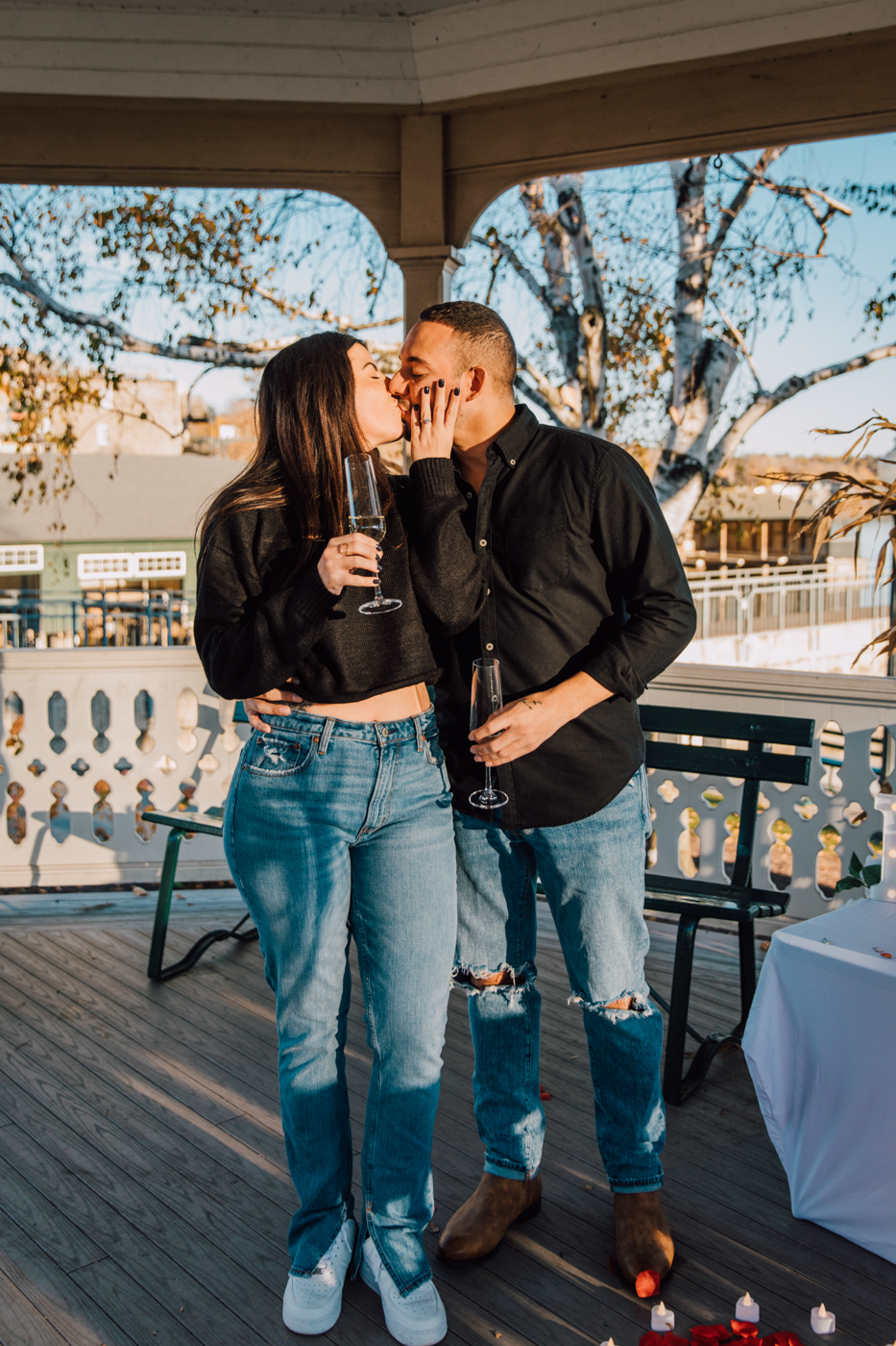  Newly engaged couple kisses during proposal pictures on Skaneateles Lake 