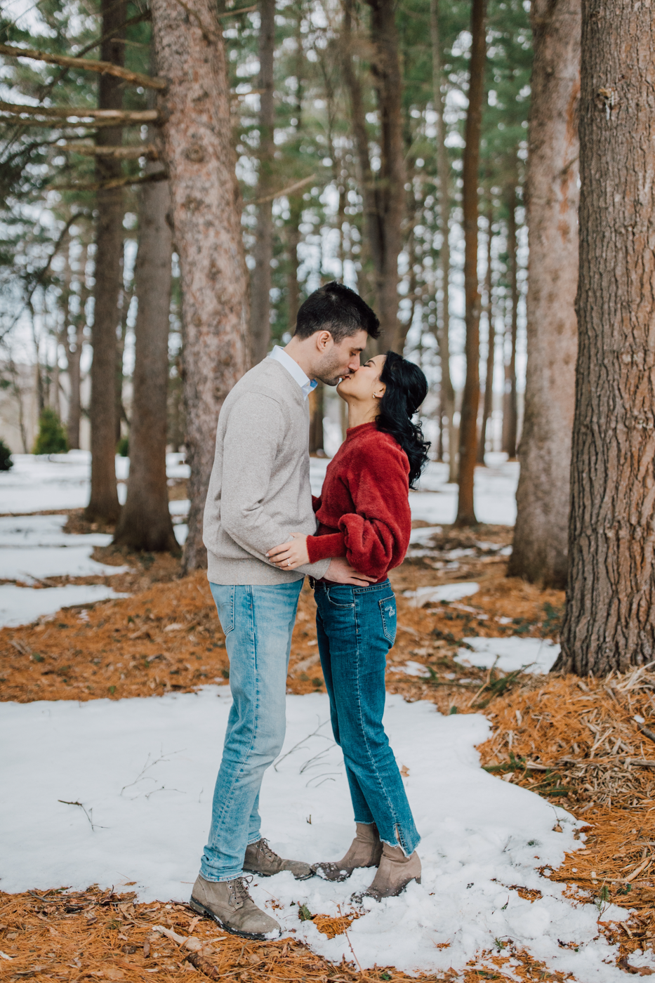  Engaged couple kisses while taking engagement photos in the snow at Lorenzo State Historic Site  