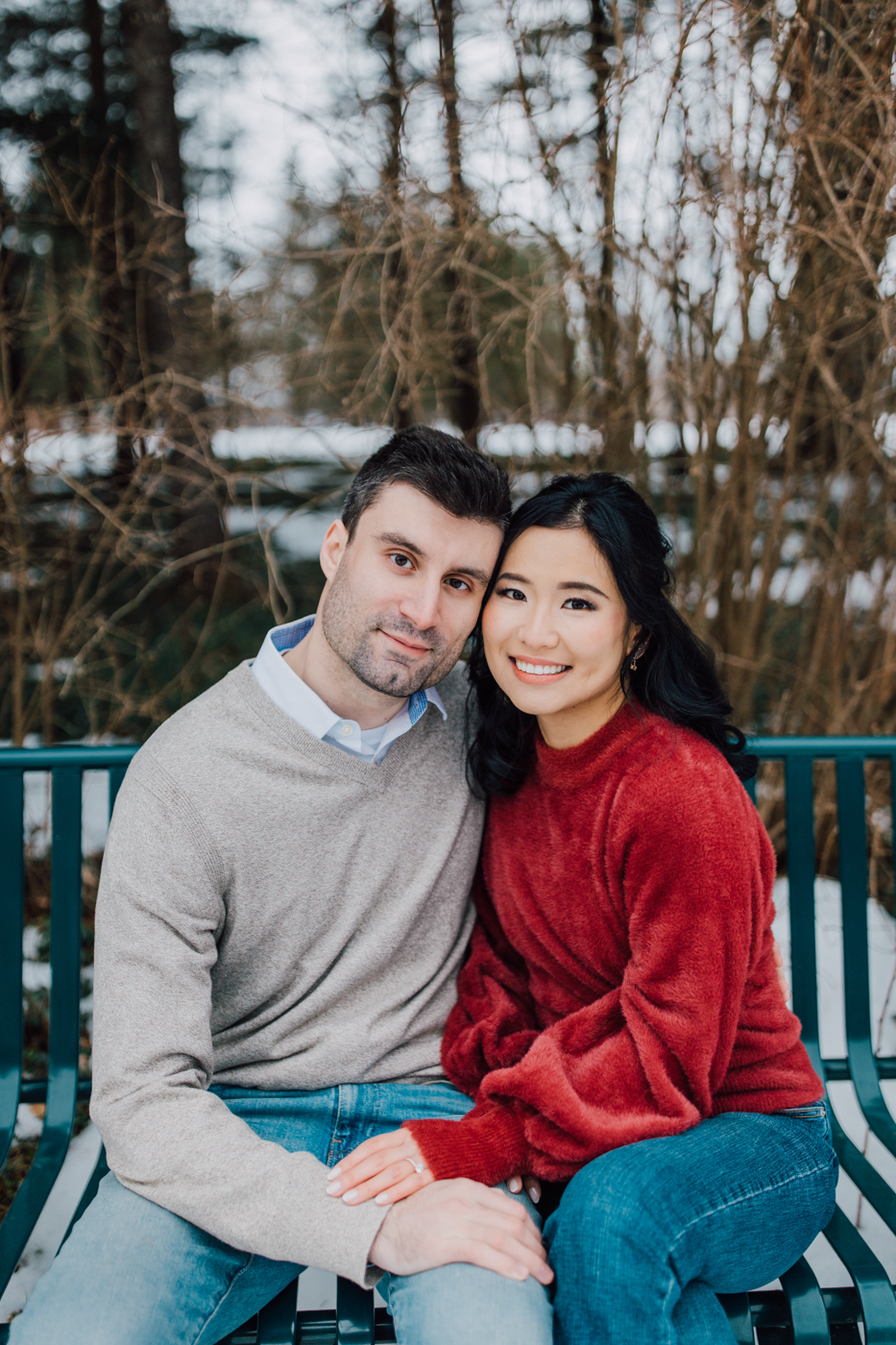  Engaged couple poses on a bench while taking winter engagement photos at Lorenzo State Historic Site in Cazenovia NY 