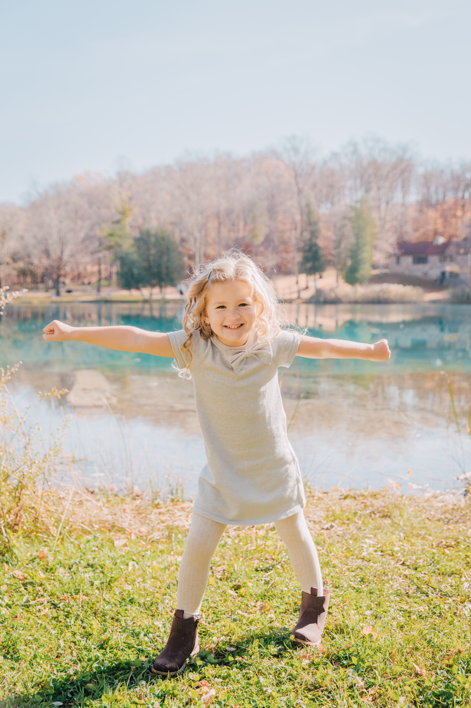  Little girl poses with her arms outstretched during a family photo session with Brittany Juravich at Green Lakes State Park 
