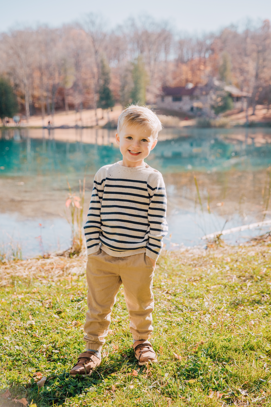  Little boy poses by a lake during family photo session at Green Lakes State Park 