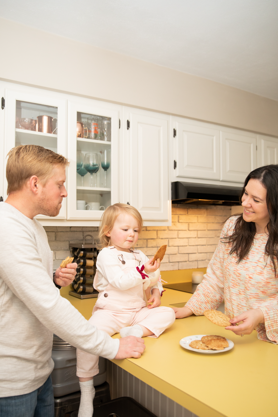  Toddler tastes a cookie during lifestyle family photography with Brittany Juravich 