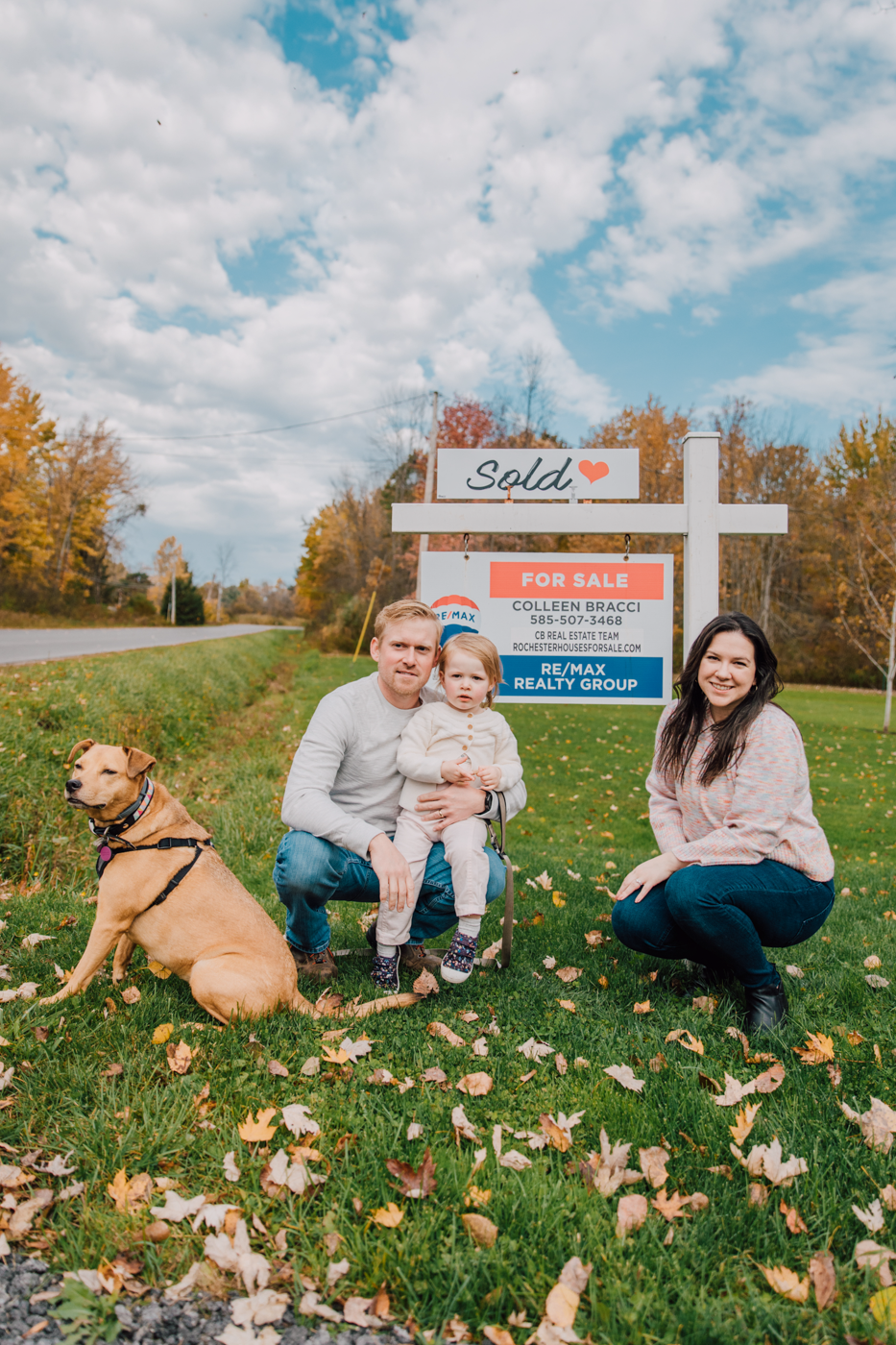  A young family poses in front of their home’s for sale sign during lifestyle family photography with Brittany Juravich 