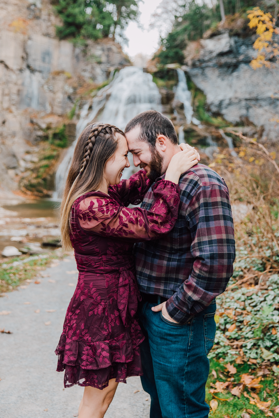  Engaged couple stand forehead-to-forehead in front of Delphi Falls during their waterfall photo shoot 
