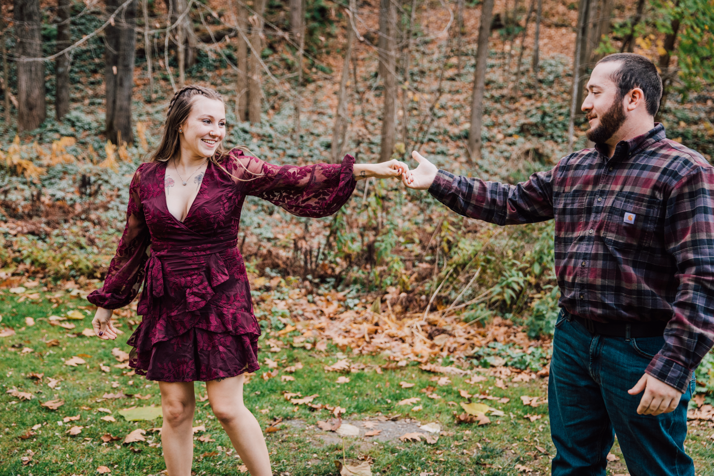  Engaged couple dances in the forest during their fall engagement photos in Cazenovia NY 