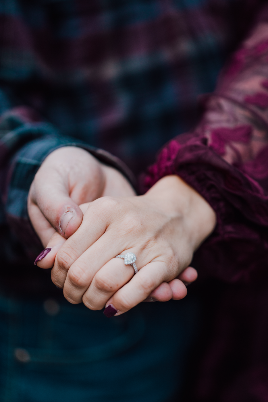  Close up on an engagement ring while an engaged couple holds hands 