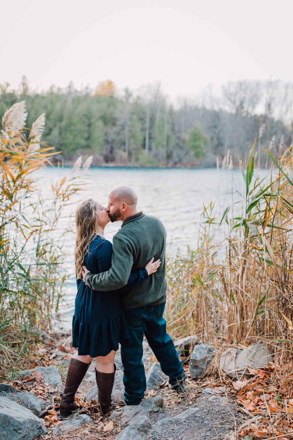  An engaged couple kisses while taking fall engagement photos at Green Lakes State Park 