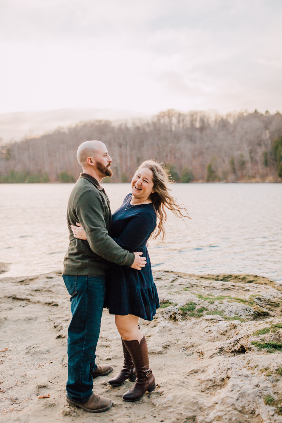  Woman laughs while standing with her fiance on the lakeshore at Green Lakes State Park 