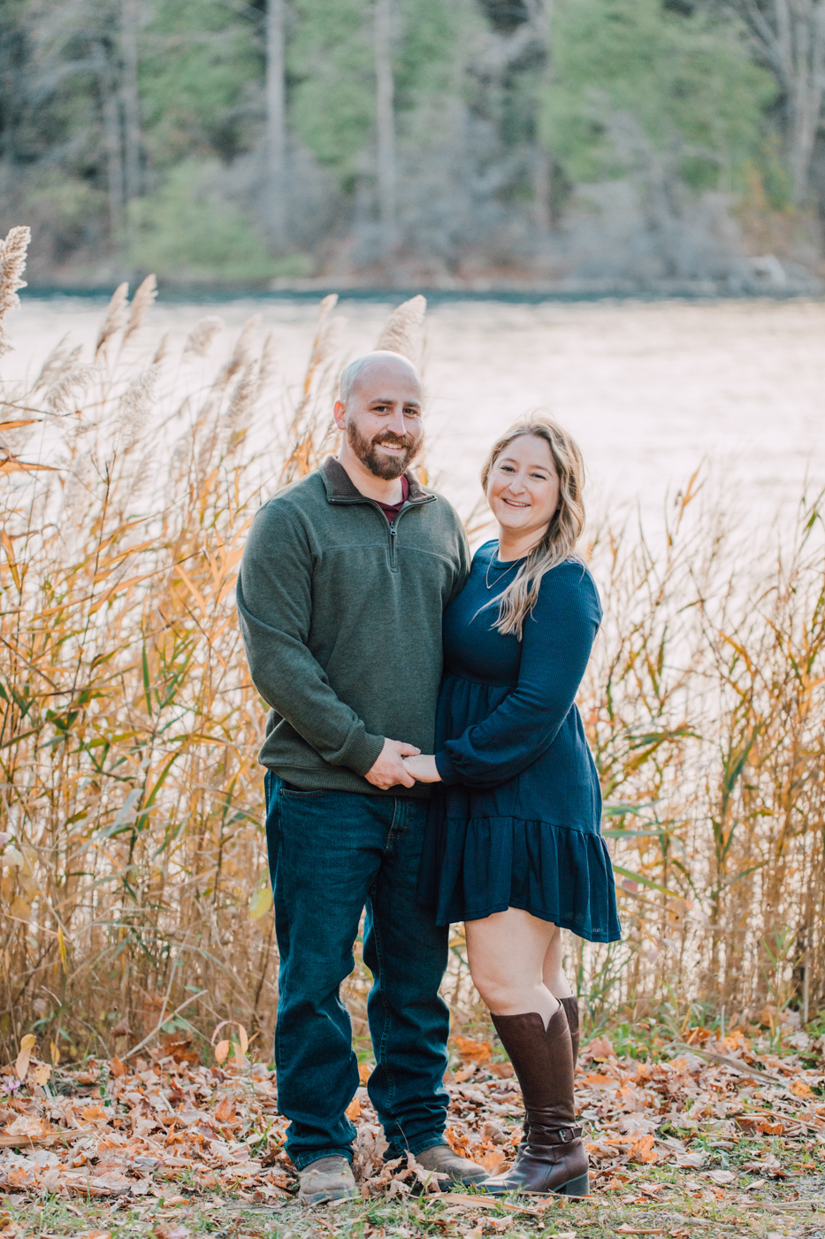  Engaged couple poses in front of a lake while taking fall engagement photos at Green Lakes State Park 