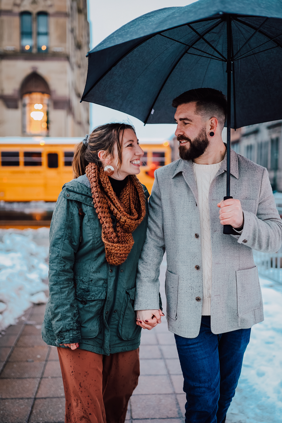  Engaged couple walks hand in hand through downtown Syracuse after their winter proposal in Clinton Square 