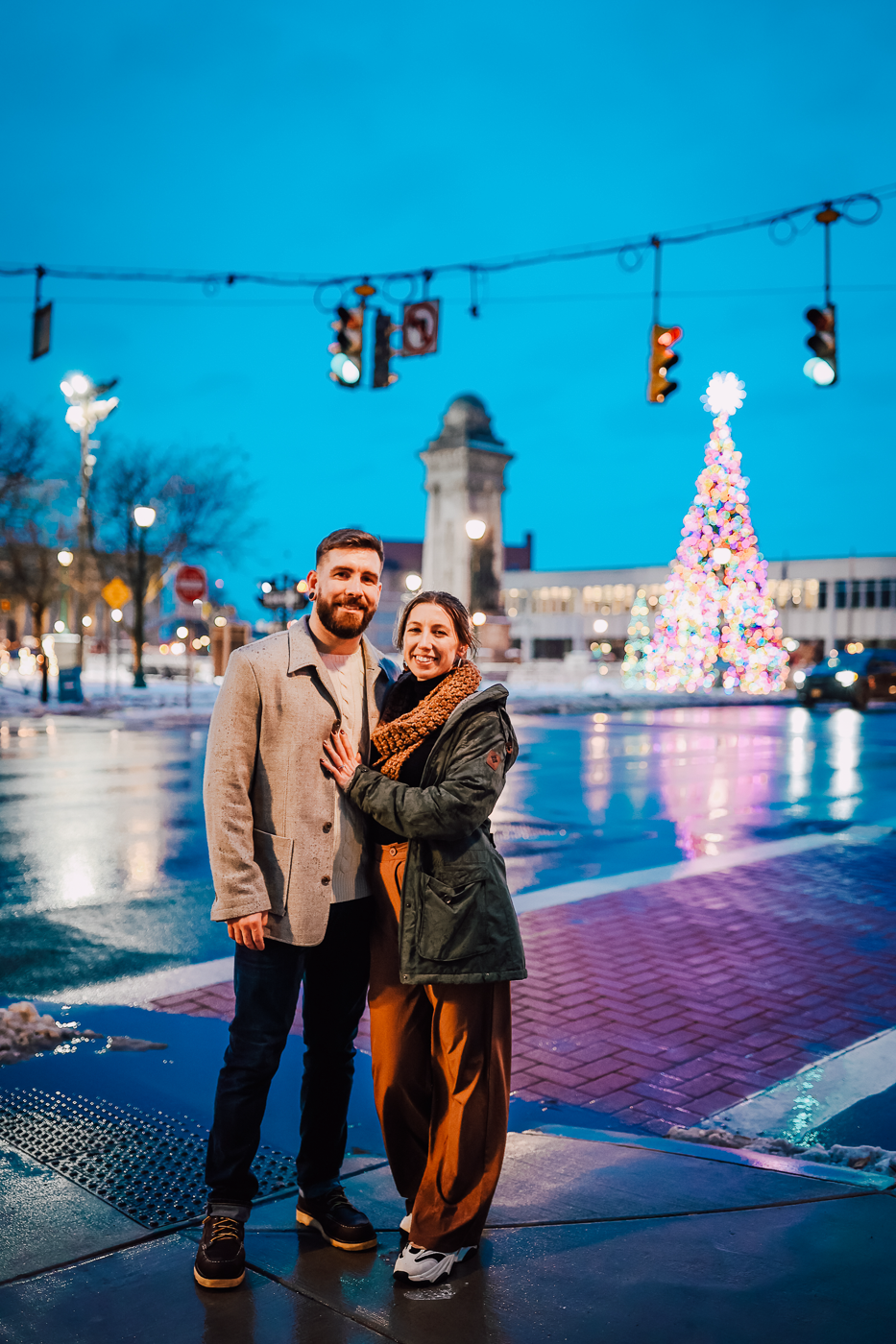  Engaged couple poses with the Syracuse NY christmas tree behind them 