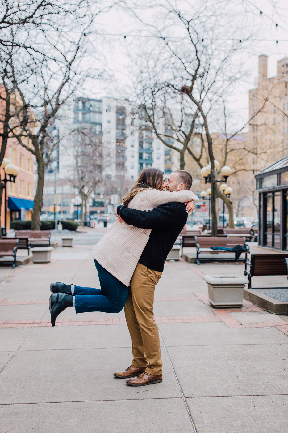  Man lifts and kisses his fiance during a winter photo shoot in downtown Syracuse 