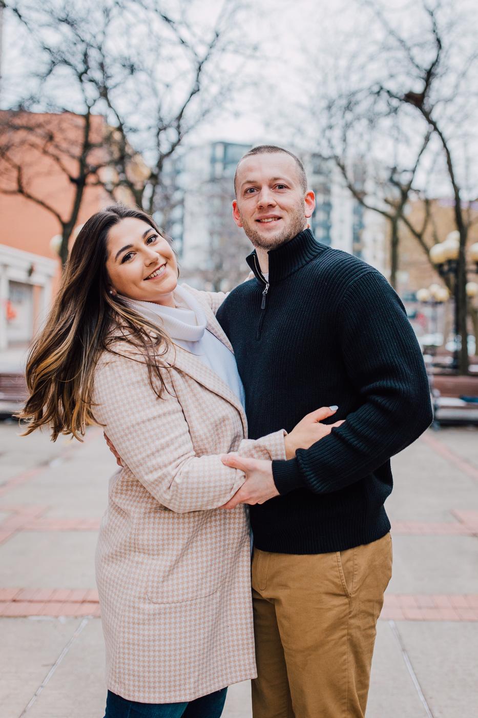  Engaged couple smiles at the camera during a winter photo shoot in Syracuse NY with Brittany Juravich 