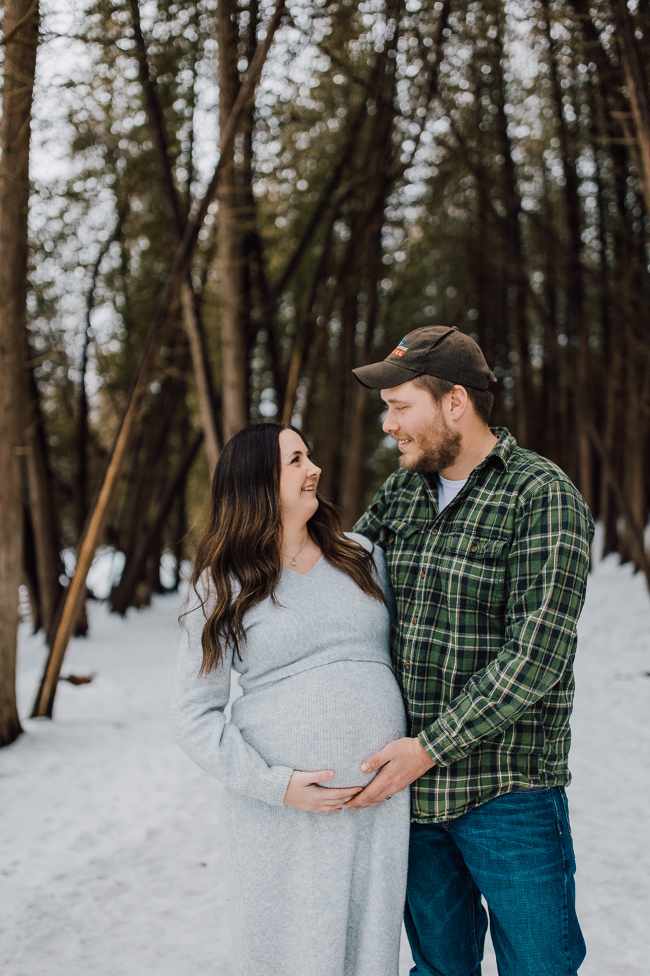  Pregnant woman and her husband hold onto her belly during their twins pregnancy announcement at green lakes state park in central NY 