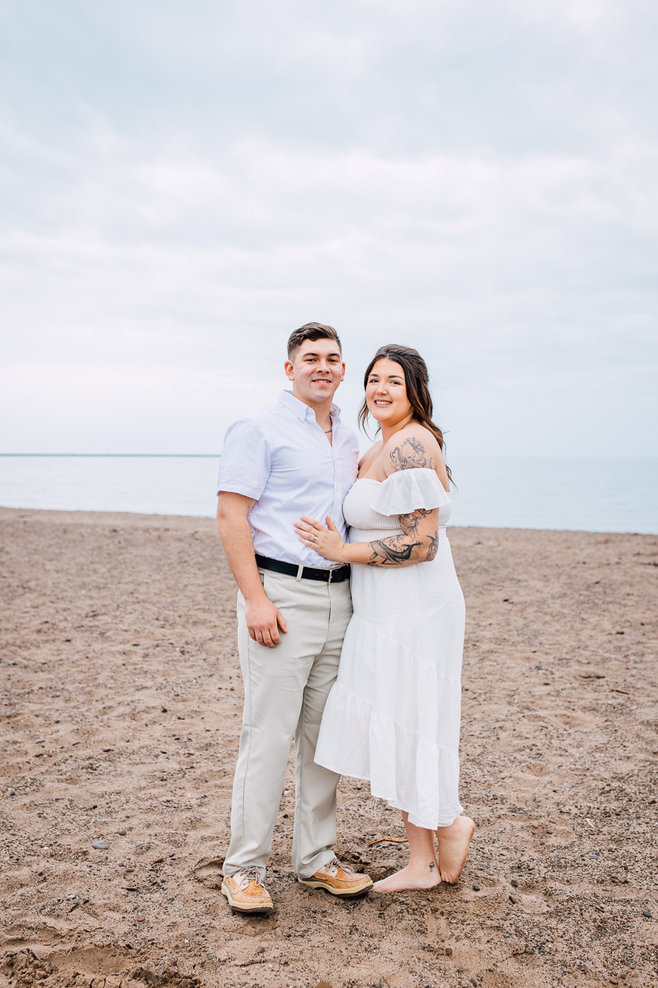  Engaged couple poses for their beach engagement photos at Fair Haven State Park in Central NY 