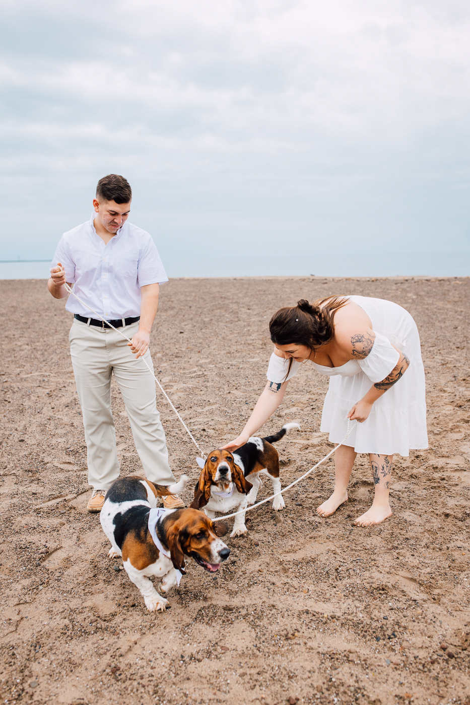  Engaged couple takes engagement photos with their dogs on a beach at Fair Haven State Park 