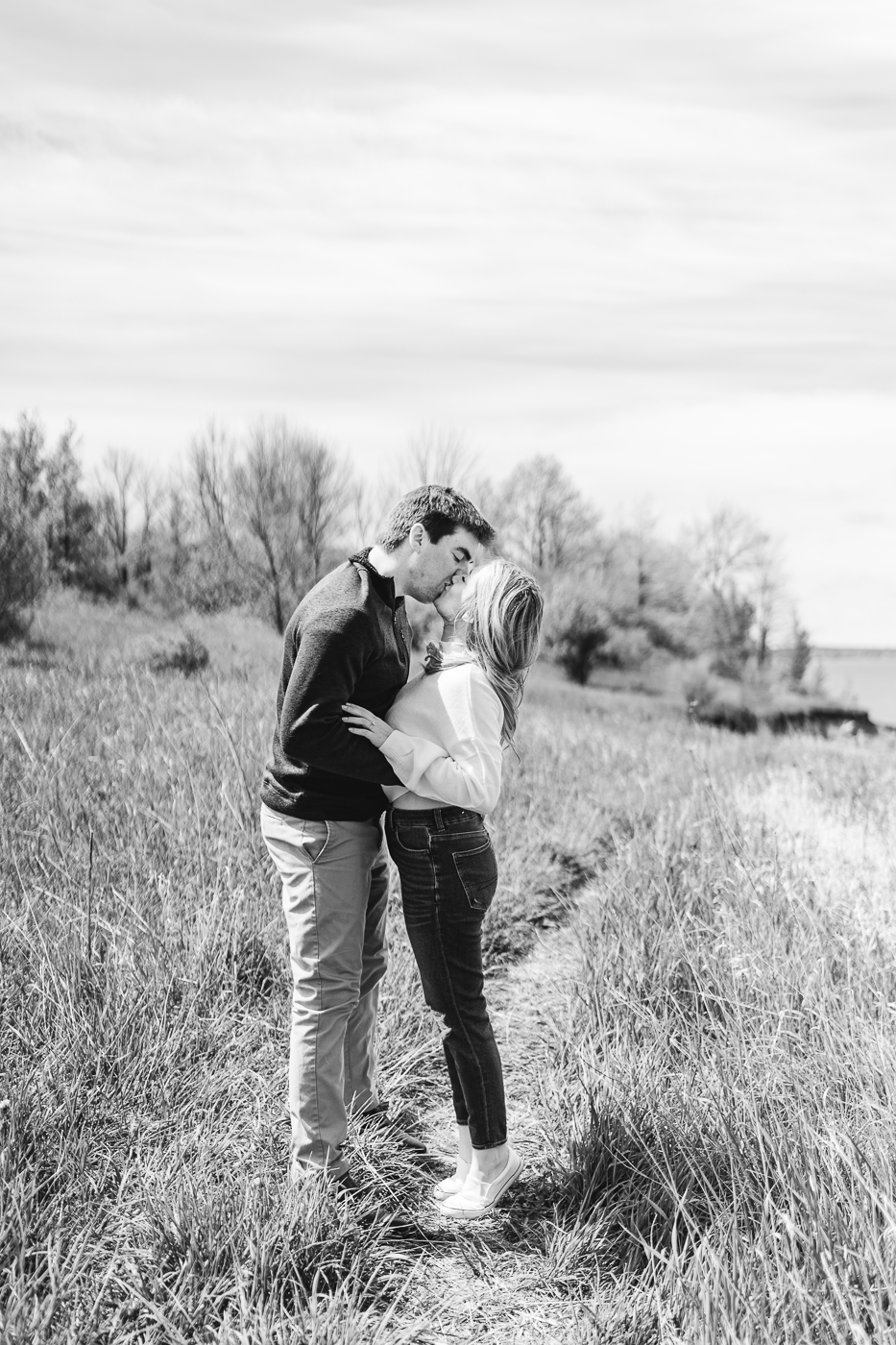  Engaged couple kisses in a black and white photo taken on the top of Sterling Bluffs for some spring engagement photos 