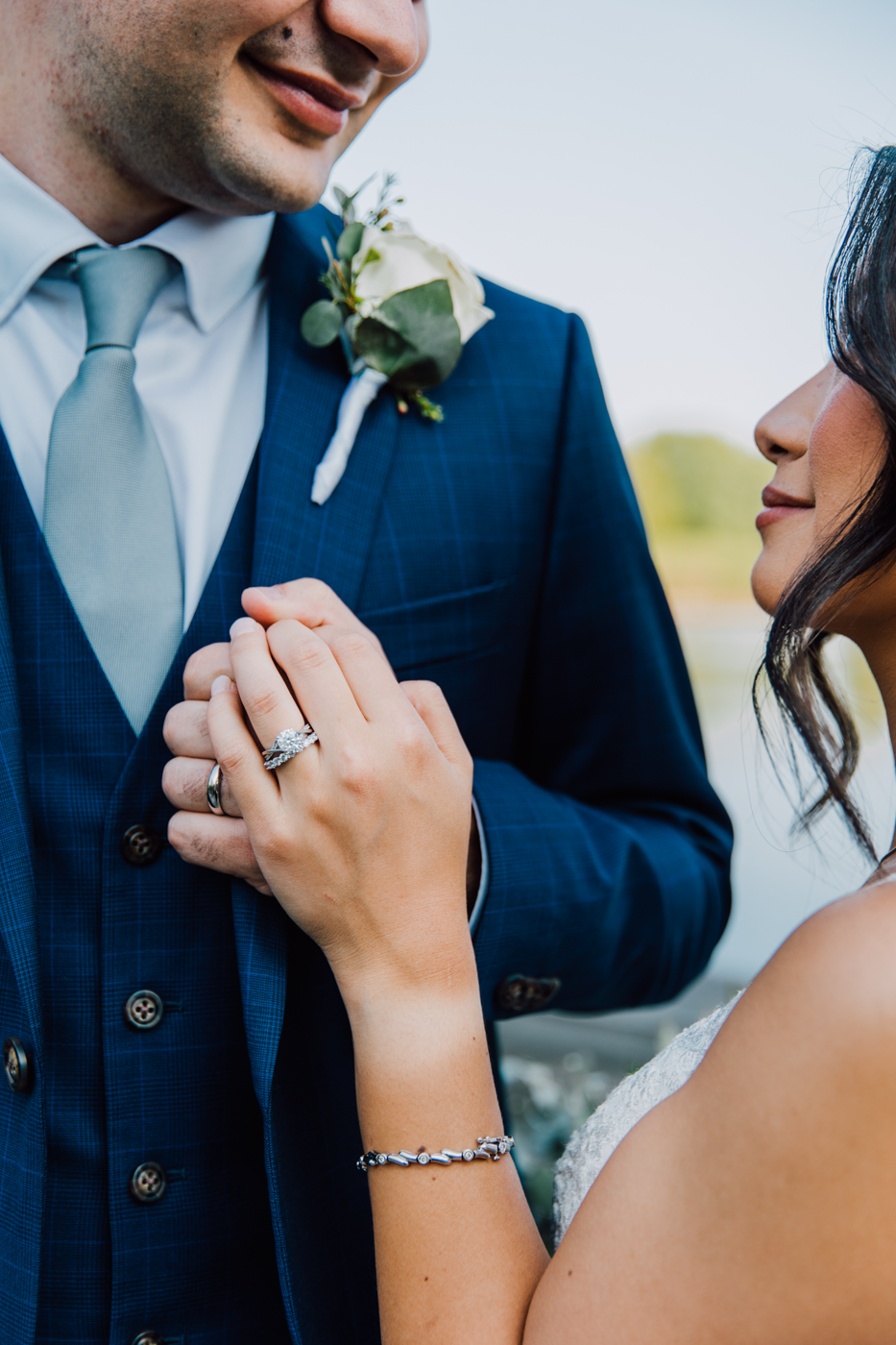  Close up of newlyweds holding hands and smiling at each other during their wedding at Lodge at Turning Stone in Central NY 