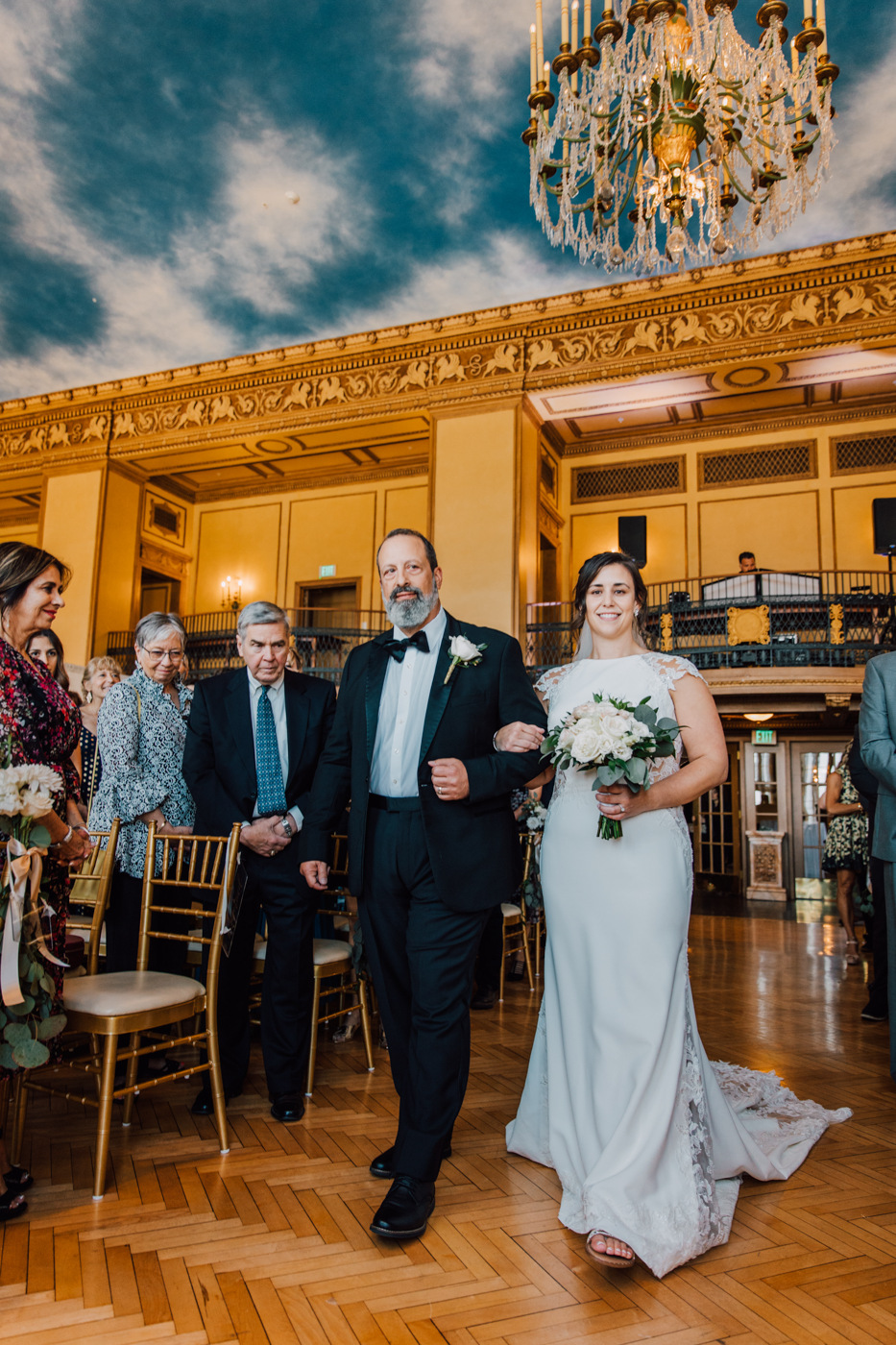  Bride walks down the aisle with her dad during their ballroom wedding at Marriott Syracuse Downtown 