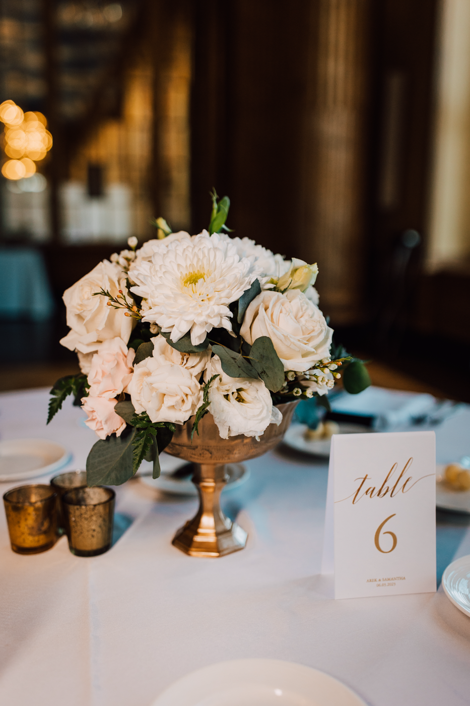  Reception decor of a floral arrangement inside a gold vase as table decor for this elegant ballroom wedding 