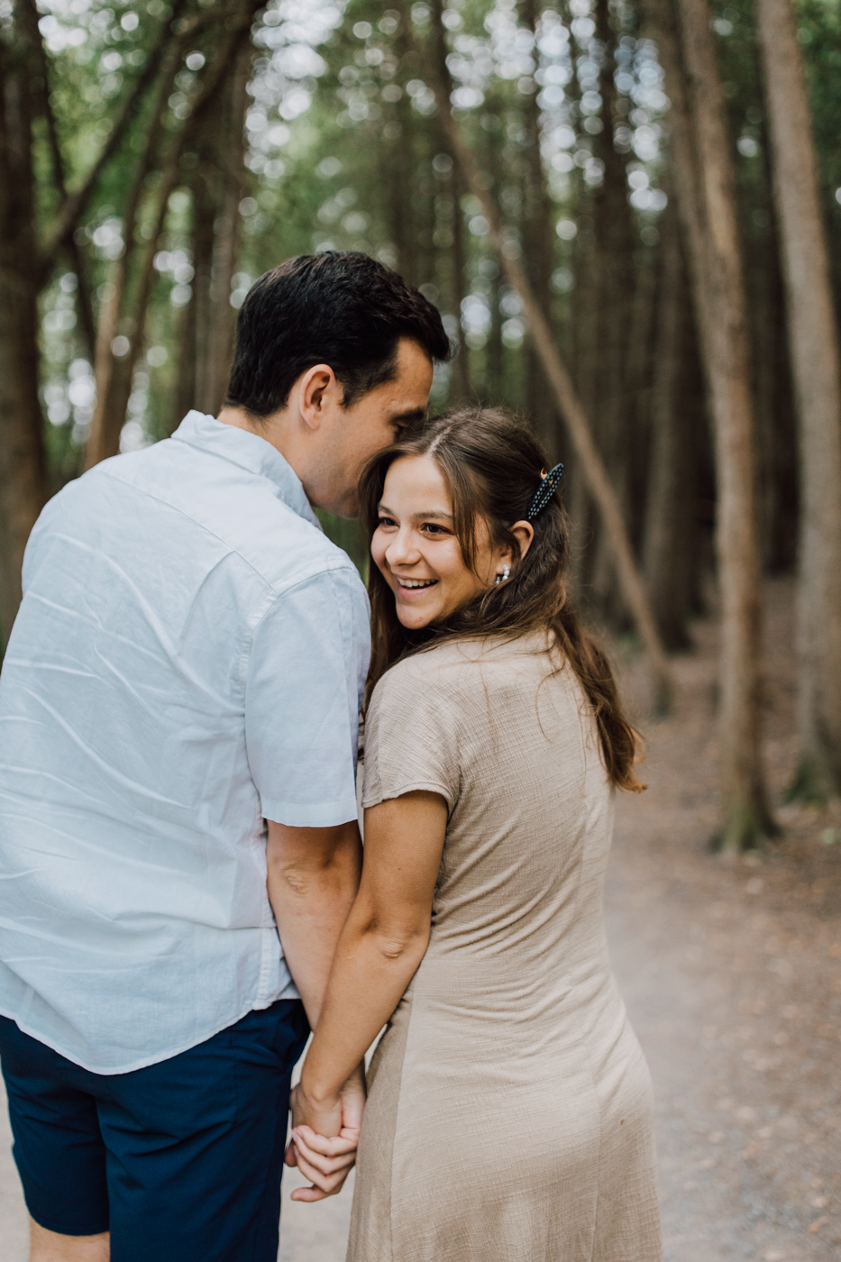  Woman laughs while holding her fiance’s hand at Green Lakes State Park during their sunset engagement photos with Brittany Juravich 