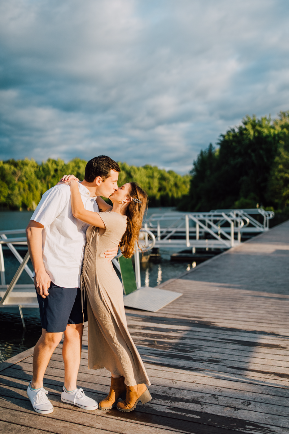  Engaged couple kisses while standing on the dock at Green Lakes State Park in Central NY 