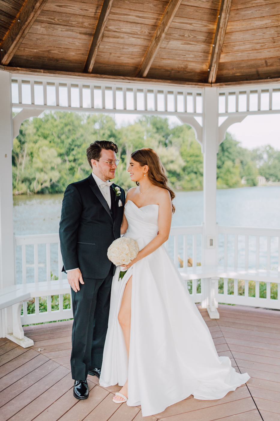  Bride and Groom stand underneath a gazebo at Timber Banks during their traditional wedding in Central NY 
