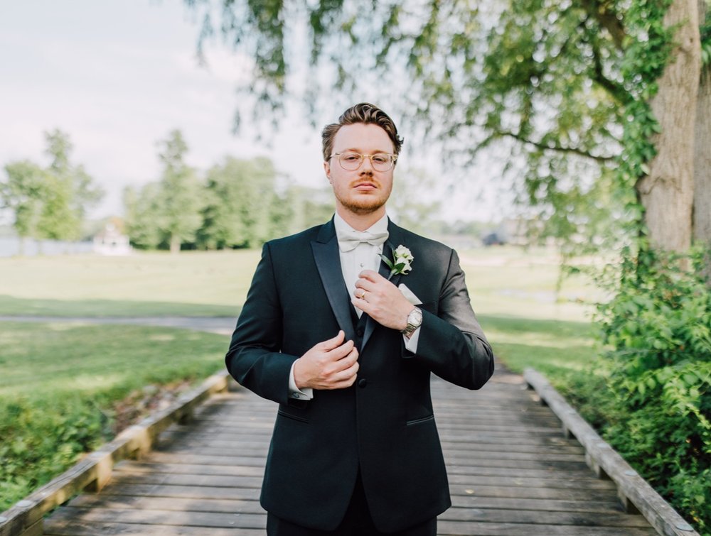  Groom adjust his tie and jacket during his traditional wedding at Timber Banks Golf Course 