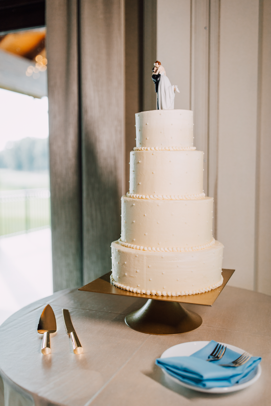  4-tier white wedding cake with simple pattern 
